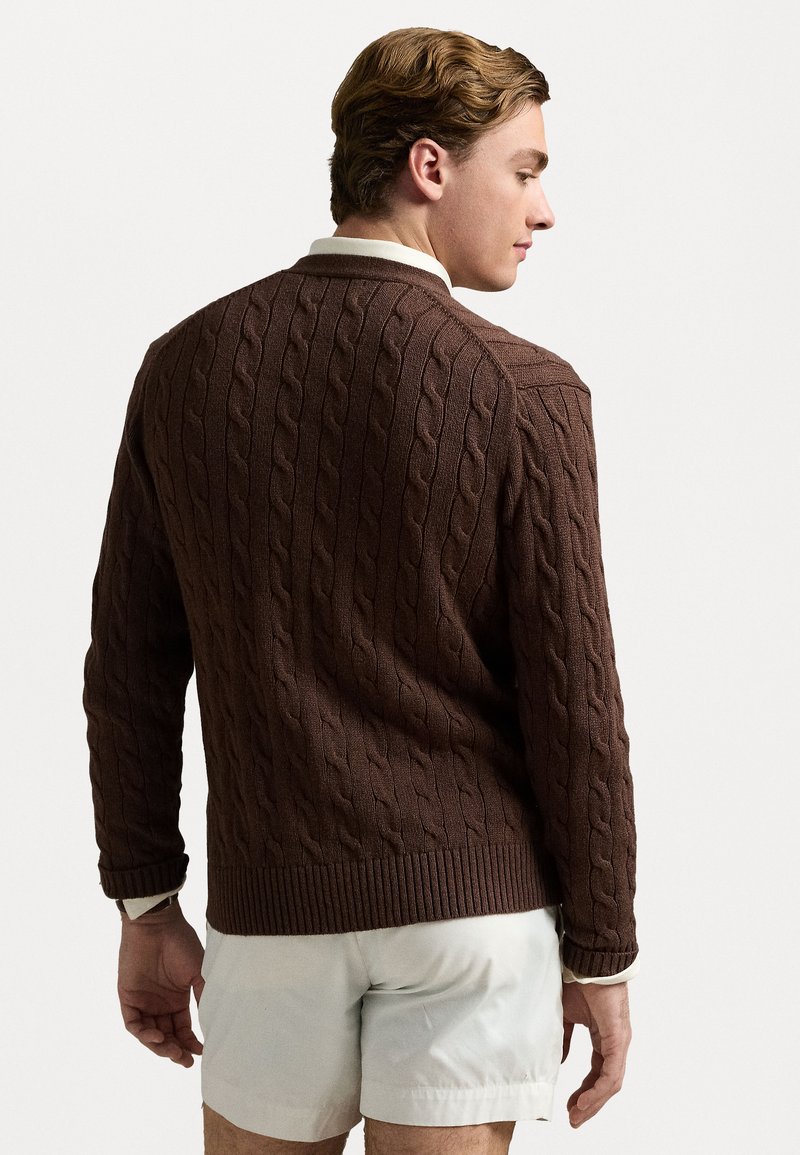 Maglione brown in maglia a treccia con orlo e polsini a coste, caratterizzato da un classico scollo a crew e un motivo testurizzato, mostrato da dietro.