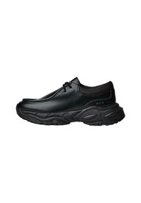 Čierne kožené slip-on topánky s okrúhlou špičkou a hrubou štruktúrovanou gumovou podrážkou. Obsahujú jemné prešitie a elastické akcenty v oblasti goliera.
