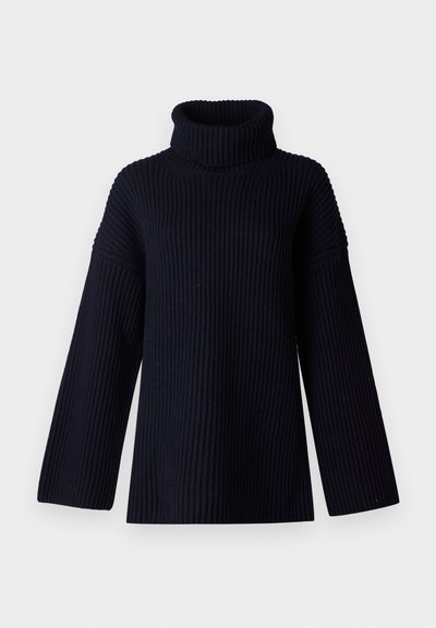 Mornarsko modra pulover s turtleneck iz ribane tkanine, širokimi rokavi in sproščenim krojem. Mehka tkanina in minimalističen dizajn.
