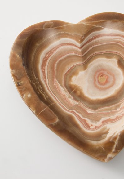 Bol din piatră onix stratificată în formă de inimă, de culoare maro și roz, cu suprafețe netede, având modele distincte și un finisaj lucios.