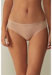 Beige Baumwoll-Slip mit glatter Textur, niedrigem Schnitt und minimalem Bund. Verfügt über nahtlose Kanten und keine sichtbaren Muster.