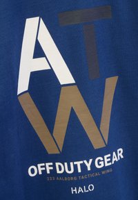 Niebieski bawełniany T-shirt z wyrazistą białą i brązową grafiką, z tekstem "OFF DUTY GEAR 223 AALBORG TACTICAL WING" oraz "HALO". Teksturowany wzór.