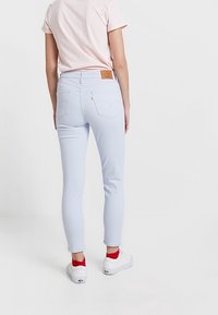 Jeans skinny azzurri chiari realizzati in materiale elastico, con un'etichetta in pelle sul retro, tasche posteriori e una finitura liscia.