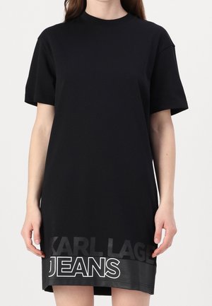 Sort bomuldst-shirtkjole med korte ærmer. Har et kontrasterende logotryk ved kanten med "KARL LAGERFELD JEANS" i hvid og grå.