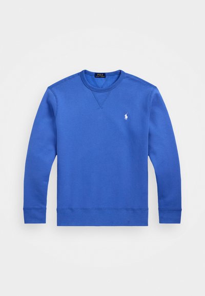 Modra dukserica iz mehkega materiala s krožnim ovratnikom, dolgimi rokavi in rebrastimi manšetami. Ima majhen bel logo na prsih.