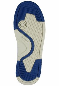 Gummisohlen von Sneakers mit einem blau-creamfarbenen Farbschema, strukturierten Grip-Mustern und einem kreisförmigen Akzent in der Mitte. Größe 37 gekennzeichnet.