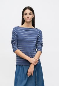 Maglia a manica lunga blu navy con righe orizzontali bianche, caratterizzata da un ampio scollo a barca e tessuto morbido e strutturato.