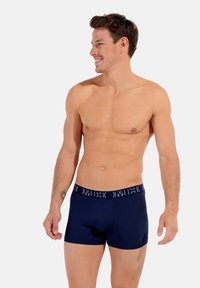 Marina blå boxershorts gjorda av mjukt tyg med en elastisk midja som har vit logotekst. Designade för komfort och en säker passform.