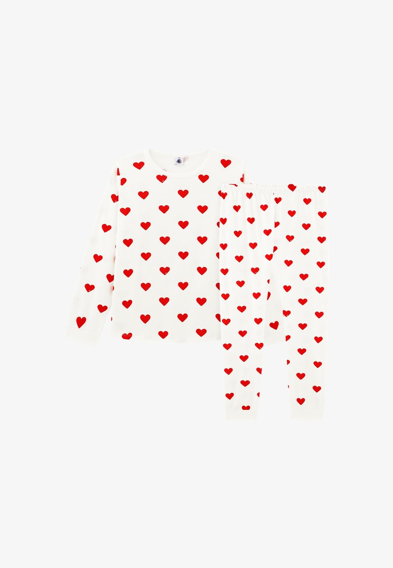 Wit pyjamapak met lange mouwen en broek, bedekt met een patroon van gelijkmatig verspreide rode hartjes.