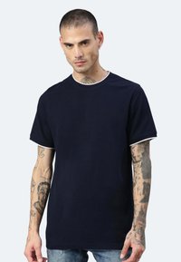 T-shirt blu navy con bordi bianchi sul colletto e sulle maniche, realizzato in tessuto morbido, caratterizzato da un colletto tondo classico e una vestibilità comoda.