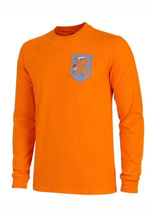 Oranje shirt met lange mouwen met een blauwe schildpatch op de borst waarop een oranje leeuw een rood-witte bal vasthoudt.