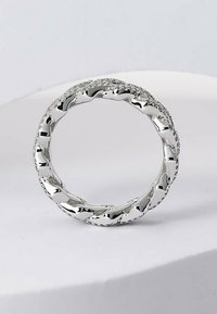 Sölvvriden ring med en glänsande yta, som har rundade och texturerade länkar som skapar en flytande, kontinuerlig design.