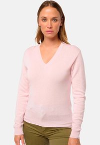 Pull v-neck rose clair en tissu doux avec des manches longues et des poignets côtelés. Texture lisse sans motifs ou accents visibles.