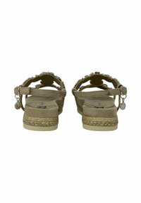 Sandali in suede beige con rifiniture dorate intrecciate, cinturino alla caviglia regolabile e dettagli decorativi. Soletta testurizzata per il comfort.