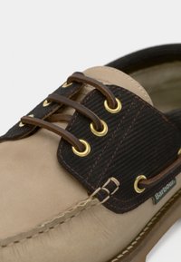 Chaussure en cuir marron clair avec accent en velours côtelé marron foncé, œillets dorés et lacets marron. Couture détaillée le long de la semelle et de l'orteil.