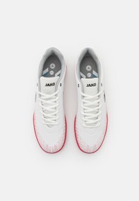 White athletic shoes with red accents, mesh upper, textured design, and contrasting grey insoles. Features "JAKO" branding on the tongue.