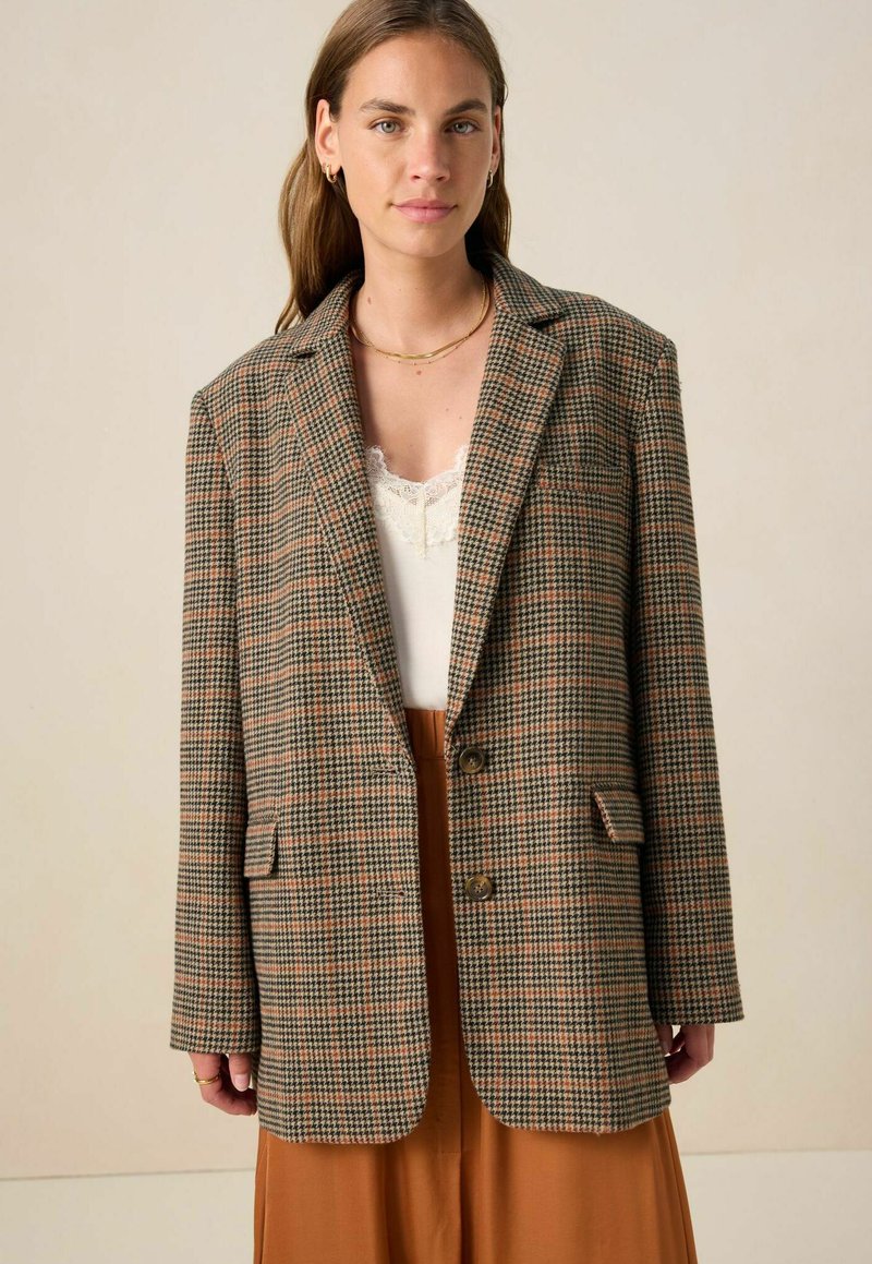 Geruit blazer in bruin, groen en beige tinten; heeft een geknipte kraag, twee voorzakken en twee knopen; losse pasvorm.