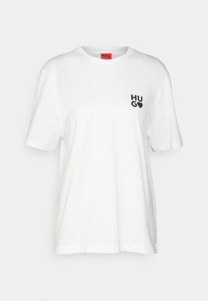 T-shirt en coton blanc à manches courtes, avec un logo noir "HUGO" dans la zone de la poitrine gauche et une étiquette rouge au niveau du col.