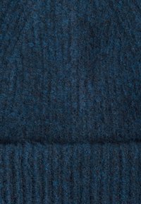 Dark blue knitted beanie featuring a textured pattern with ribbed detail at the base, made from soft, warm material.