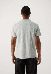 Graues Baumwoll-T-Shirt mit kurzen Ärmeln, Rundhalsausschnitt und glatter Textur. Keine sichtbaren Muster oder Akzente. Einfaches Design auf der Rückseite.