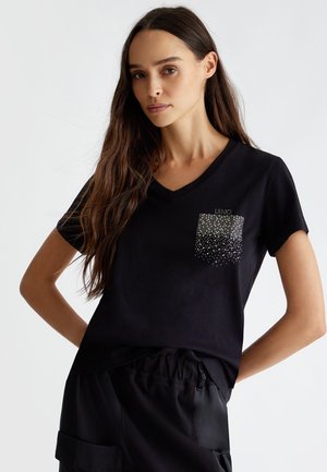 T-shirt nera a maniche corte con scollo a V, caratterizzata da un design con tasca decorata con strass sparsi. Tessuto morbido.