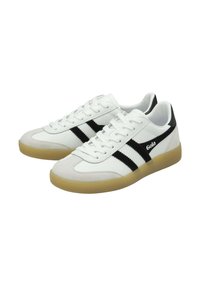 Zapatillas blancas con rayas negras y logo, puntera de ante, suela de goma y cierre de cordones. Presenta superficies lisas y texturizadas.