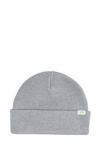 Cappello in maglia grigia con risvolto, dotato di una piccola etichetta in tessuto con un logo. La texture è a coste e elastica.