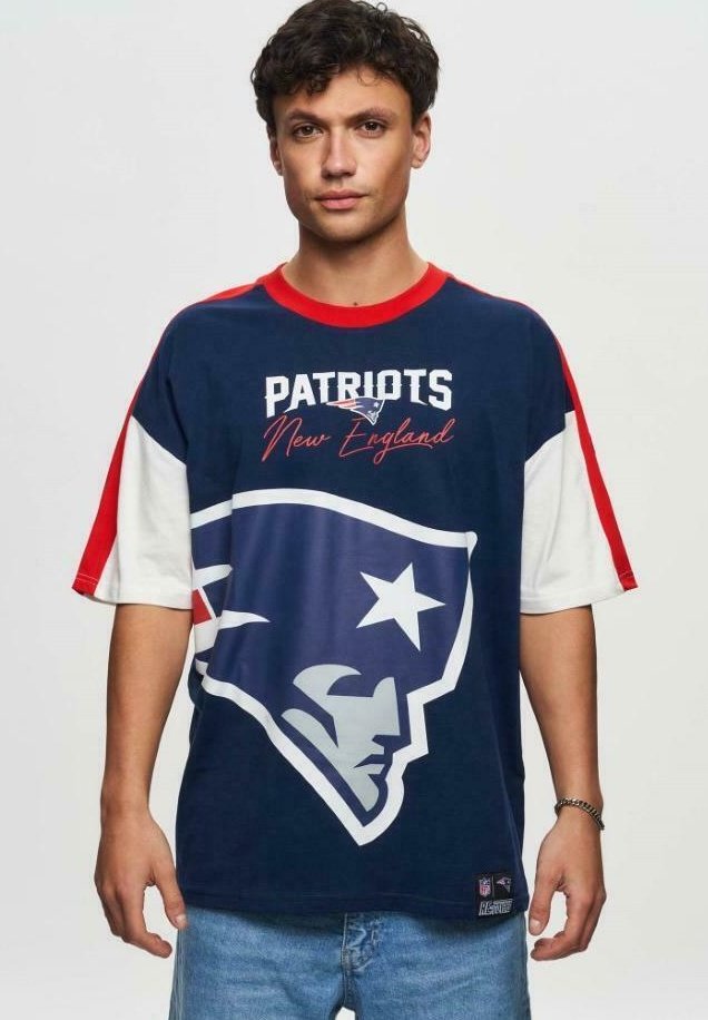 Tummansininen NFL-t-paita, jossa on New England Patriotsin logo, punaiset ja valkoiset yksityiskohdat hihoissa, lyhyet hihat ja rento malli.