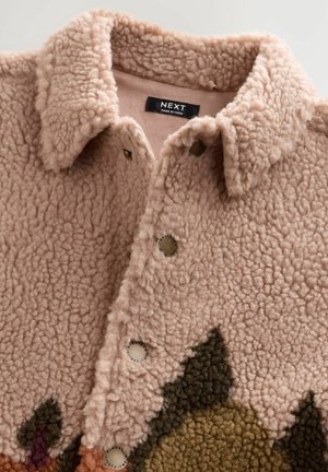 Jachetă din fleece de culoare roz pal, cu o suprafață texturată. Prezintă un decolteu cu guler, închidere cu buton și o secțiune inferioară trebuie modelată în tonuri pământii.