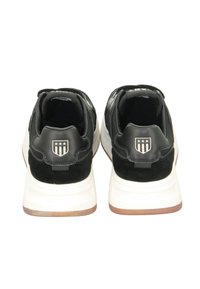 Schwarze Wildleder- und Stoff-Sneaker mit weißer Sohle, ausgestattet mit einem Logo-Patch und drei Sternen-Details auf der Rückseite. Texturiertes Obermaterial und gepolsterter Kragen.