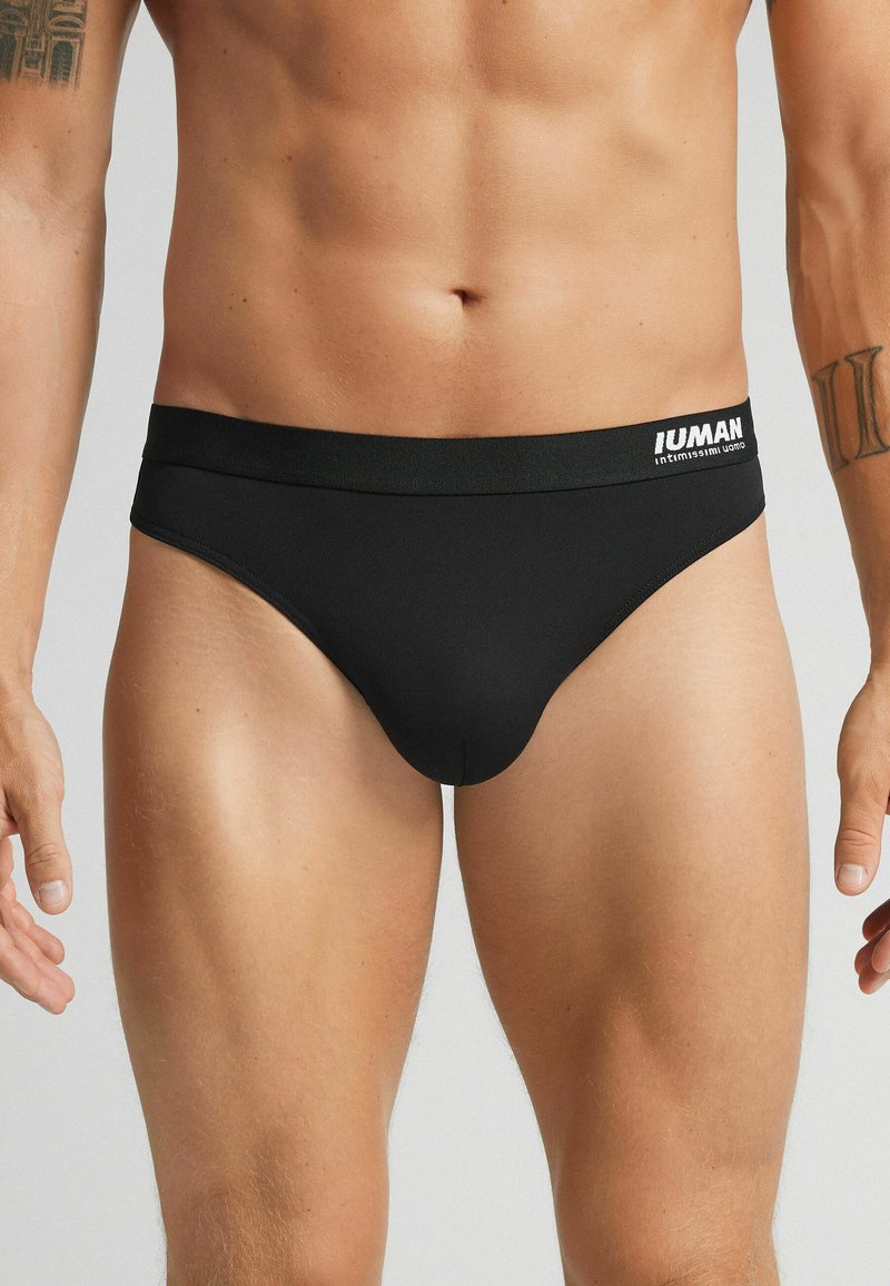 Schwarze Männerunterwäsche mit breitem elastischem Bund und weißem "IUMAN"-Logo. Glatte Textur und enganliegendes Design, geeignet für angenehmen Tragekomfort.