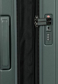 Hartschalenkoffer in Dunkelgrün mit strukturiertem Finish, ausgestattet mit einem Doppelsipper, TSA-Schloss und einem seitlichen Griff für einfachen Transport.