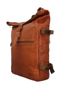 Brauner Lederrucksack mit vorderer Reißverschlusstasche, Schnallenverschluss und verstellbaren Seitenträgern vor weißem Hintergrund.