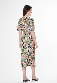 Abito multicolore con un motivo floreale paisley, maniche corte, e lunghezza midi, dotato di uno spacco laterale e una texture di tessuto fluida.