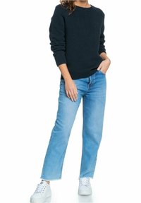 Pull bleu marine texturé, col rond ; associé à un jean droit bleu clair et des baskets blanches. Tenue simple et décontractée.