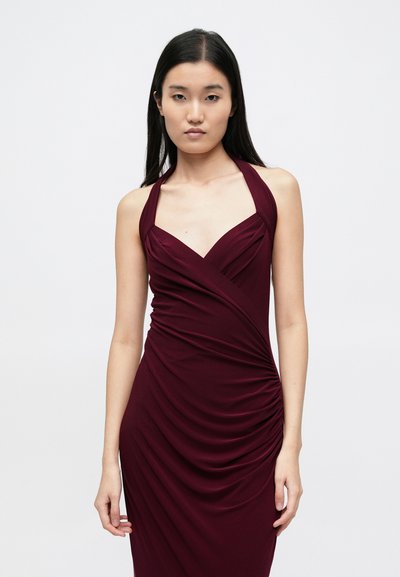 Vínové šaty s halter výstřihem, záhyby látky a přiléhavým střihem. Mají centrální shrnovací detail podél strany. Hladká textura.