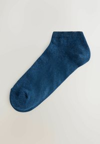 Calcetín azul marino para el tobillo, extendido sobre un fondo gris claro, mostrando la textura de tejido y el puño elástico.