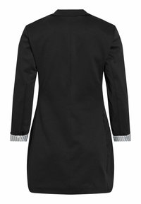 Zwarte lange blazer met getailleerde taille, lange mouwen en omslagmanchetten die witte stof met zwarte strepen tonen.