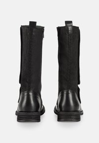 Botas negras de tobillo con una combinación de cuero liso y ante texturizado. Cuenta con una cremallera trasera y un tacón bajo y apilado.