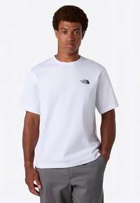 White short-sleeve t-shirt made of cotton, featuring a small blue logo on the left chest area and a classic crew neckline.