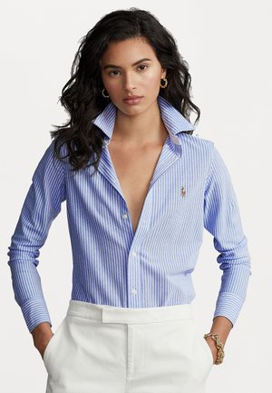 Striped button-up shirt in light blue and white, featuring a classic collar and long sleeves. Embroidered logo on the chest. Smooth fabric.
