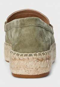 Olivu zaļš zamšāda espadrilles ar austu jutu zoli. Iespējas šūtā mala un mīksts, izliekts aizmugure nodrošina ērtu valkāšanu. Līdzena papēža.