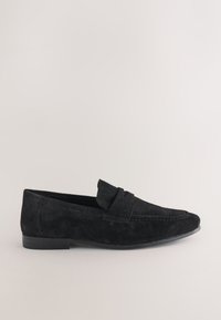 Mocassin pour homme en daim noir avec un petit talon et une bride sur le dessus, montré de profil sur un fond uni.
