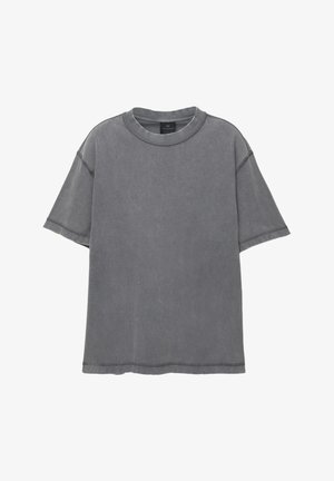 T-shirt grigio oversize in cotone. Presenta un collo tondo, maniche corte e dettagli sfrangiati lungo le cuciture e l'orlo.