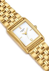 Zelta tonis metāla pulkstenis ar taisnstūra korpusu, balta teksturēta ciparnīca, zelta stundu atzīmes un austs rokturis. Iekļauta regulējama aizdare.