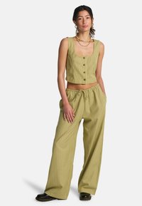 Περικομμένο αμάνικο τοπ με ριγέ φωτεινό ελιά χρώμα και κουμπιά στο εμπρόσθιο μέρος, σετ με παντελόνι φαρδιάς γραμμής με ελαστική μέση και τσέπες.