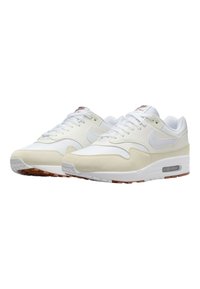 Vita Nike Air Max-sneakers är gjorda av en kombination av mjukt läder och texturerad mocka. De har en synlig luftenhet och en gummisula.