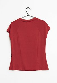 Rød kortærmet top med rund halsudskæring, glat tekstur og en tætsiddende design. Har raglanærmer og en søm, der buer let.
