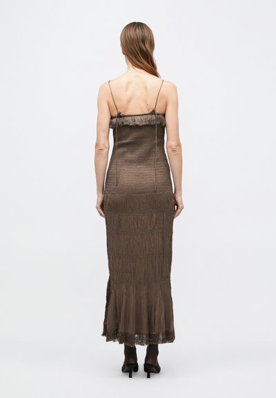 Barna, maxi ruha spagetti pántokkal. Flecos felsőrészt és texturált, rétegzett anyagot tartalmaz. Finom fényű, bővülő szegéllyel.