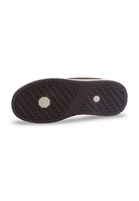Semelle de chaussure avec une surface en caoutchouc noir texture, présentant un logo en métal hexagonal et un motif géométrique pour l'adhérence.